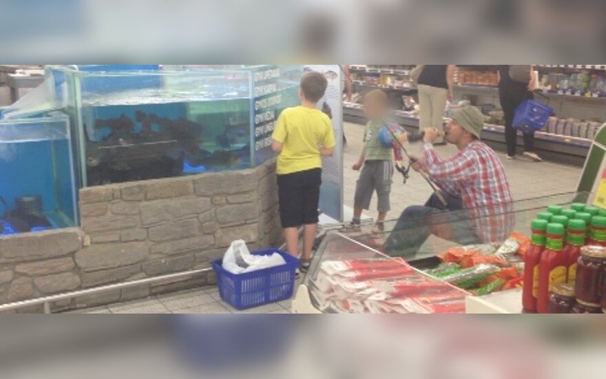 Łapał rybę w akwarium w supermarkecie