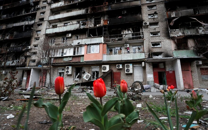 Priešais namą, kuris buvo stipriai apgriautas per Rusijos karą prieš Ukrainą, pražydo tulpės. Pietinis Mariupolis, Ukraina, 2022 balandžio 21 d. 