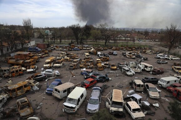 Suniokoti automobiliai sunaikintoje Ilicho metalurgijos gamyklos dalyje. Fone kyla dūmai iš Azovstal gamyklos, kur vyksta intensyvi kova tarp Rusijos ir Ukrainos pajėgų. Prorusiškų pajėgų kontroliuojamas Mariupolis, Ukraina. 2022 balandžio 18 d. 