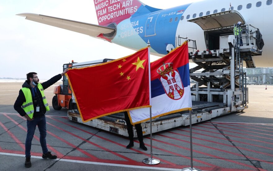 A man holds China s flag next to Serbia s flag as a plane transporting one million doses of Sinopharm s China National Biotec Group (CNBG) vaccines for the coronavirus disease (COVID-19) arrives at Nikola Tesla Airport in Belgrade, Serbia, January 16, 2021. 